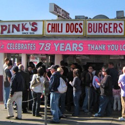 People standing in line in front of Pink's Hot Dogs